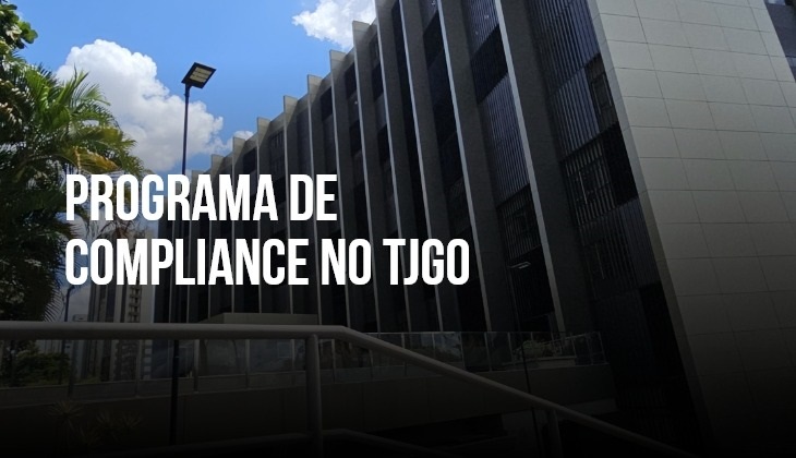 A imagem mostra a fachada do prédio do TJGO em Goiânia, sob um céu azul com algumas nuvens. Em destaque, no centro da imagem, aparece a inscrição em letras brancas: “PROGRAMA DE COMPLIANCE NO TJGO”, sobre um fundo escurecido que valoriza o texto. O ângulo da foto reforça a imponência do edifício, com colunas verticais e uma composição arquitetônica moderna, transmitindo seriedade e institucionalidade — alinhada ao tema da integridade e governança.