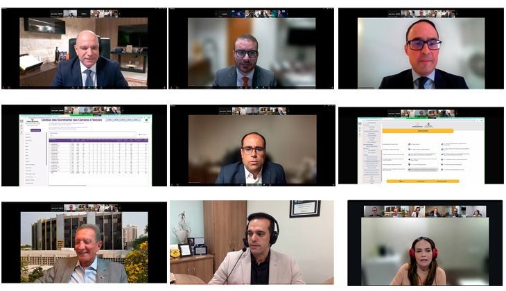 A imagem é uma montagem composta por nove capturas de tela de uma videoconferência, organizadas em formato de grade (três linhas por três colunas), com fundo preto ao redor.  Na primeira linha, aparecem três participantes em destaque, todos vestidos de forma formal (terno e gravata ou blazer), cada um em seu respectivo ambiente interno, como escritórios ou salas bem iluminadas.  Na segunda linha, a primeira e a terceira imagens mostram telas compartilhadas com apresentações ou sistemas exibindo tabelas e menus. No centro, há outro participante em enquadramento aproximado, também vestido formalmente, com fundo levemente desfocado.  Na terceira linha, aparecem mais três participantes em ambientes internos. Um deles utiliza fones de ouvido com microfone, indicando que pode estar falando no momento. Todos aparentam estar participando de uma reunião ou webinar profissional.  No topo de algumas telas é possível ver a barra típica de plataforma de videoconferência, com miniaturas dos demais participantes, reforçando que se trata de um evento online, possivelmente institucional ou corporativo.
