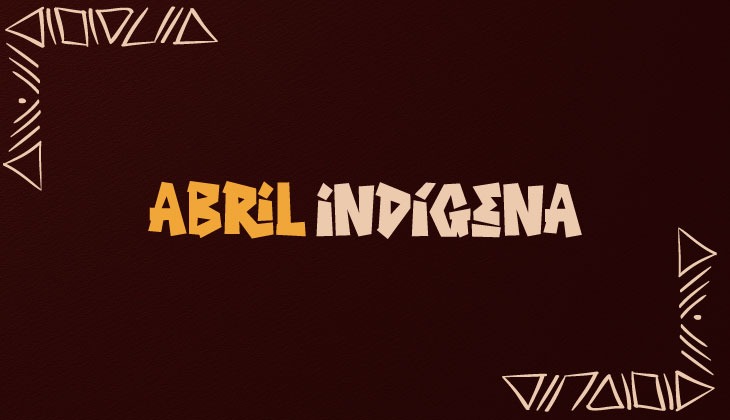 Imagem com fundo em tom vermelho escuro, com leve textura. No centro, está escrito “Abril Indígena” em letras grandes e estilizadas, nas cores amarelo e bege, com aspecto artesanal. Nos cantos da imagem, há elementos gráficos geométricos em linhas claras, que lembram grafismos indígenas, distribuídos no canto superior esquerdo e no canto inferior direito, compondo uma moldura visual. Não há presença de pessoas.