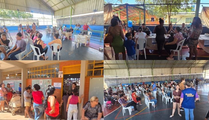 A imagem é uma montagem composta por quatro fotografias que retratam um atendimento comunitário realizado em um espaço público.  No canto superior esquerdo, há uma quadra coberta com várias pessoas sentadas em cadeiras de plástico branco, organizadas em filas. Algumas aguardam atendimento, enquanto outras conversam. Ao fundo, mesas com profissionais atendendo o público.  No canto superior direito, o atendimento acontece em uma área aberta, com mesas onde servidores conversam com moradores. Há adultos e crianças próximos, e algumas pessoas estão em pé aguardando sua vez.  No canto inferior esquerdo, a cena mostra a entrada de um prédio, possivelmente uma escola ou unidade pública. Pessoas formam uma fila do lado de fora, enquanto outras entram ou saem. Um carrinho de bebê aparece entre os presentes.  No canto inferior direito, novamente uma quadra coberta, com grande número de pessoas sentadas em cadeiras organizadas. Uma mulher em primeiro plano veste uma camiseta azul com a inscrição “Goiás Social”, indicando tratar-se de uma ação social. O ambiente é movimentado, com muitas pessoas aguardando atendimento.  De forma geral, a montagem transmite a ideia de um mutirão de serviços, com participação expressiva da comunidade em diferentes pontos de atendimento.