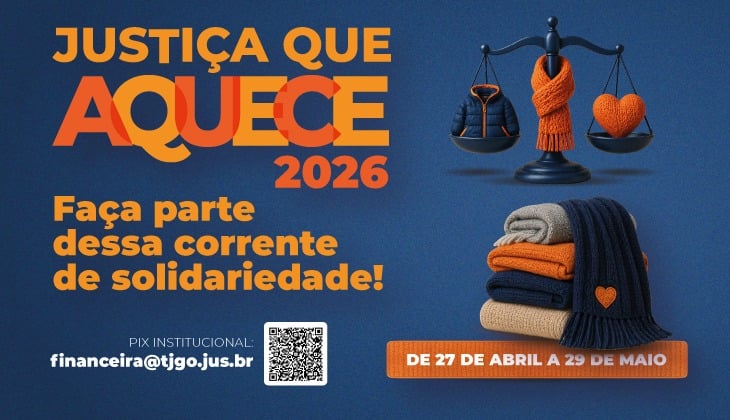 Imagem institucional com fundo azul-escuro e elementos em tons de laranja e azul.  À esquerda, em destaque, o título em letras grandes: “JUSTIÇA QUE AQUECE 2026”. Logo abaixo, em fonte menor, a chamada: “Faça parte dessa corrente de solidariedade!”. Na parte inferior esquerda, aparece a informação de PIX institucional com o e-mail “financeira@tjgo.jus.br ” ao lado de um QR Code.  À direita, há uma ilustração de uma balança da justiça estilizada. Em um dos pratos, estão um casaco e um cachecol; no outro, um cachecol enrolado em formato de coração. Abaixo da balança, há uma pilha de roupas dobradas (mantas e agasalhos) em cores neutras e azul, com um cachecol azul com um pequeno coração laranja sobreposto.  No canto inferior direito, um selo em formato arredondado informa o período da campanha: “DE 27 DE ABRIL A 29 DE MAIO”. A composição visual remete a uma campanha solidária de arrecadação de roupas para o frio.